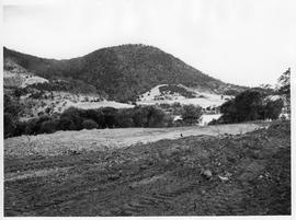 Cleared land with hills in background